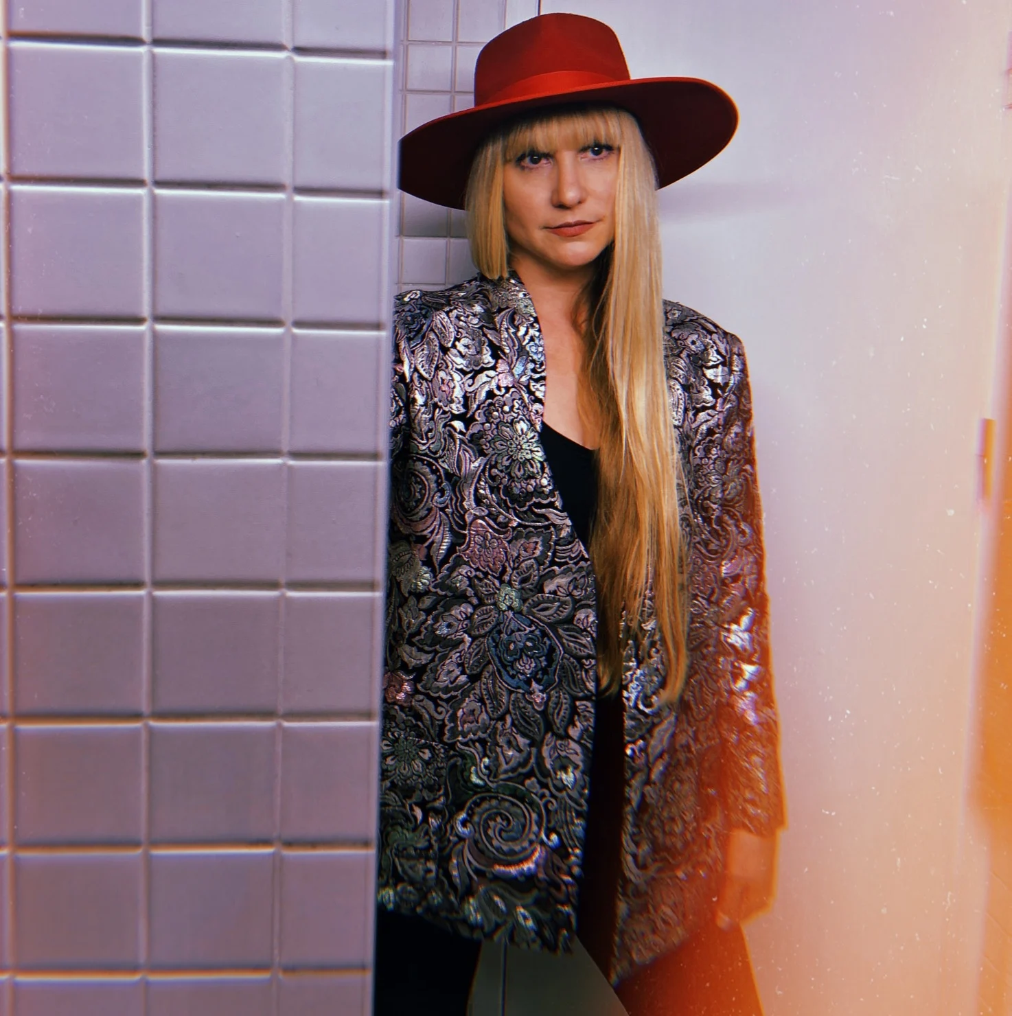 Bella in a red hat and richly patterned jacket
